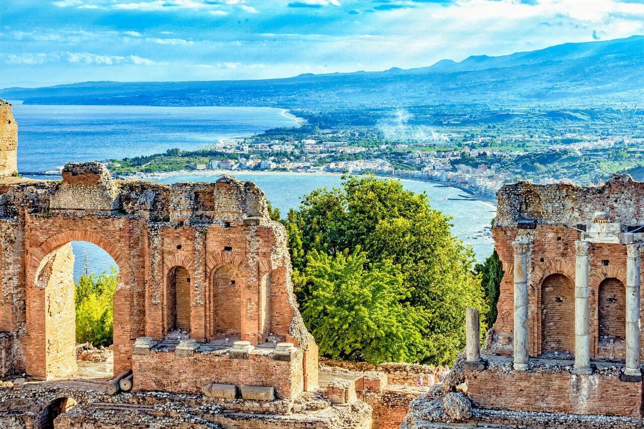 Ancient Greek ruins on the coast of Giardini Naxos, Sicily, with Mount Etna in the background